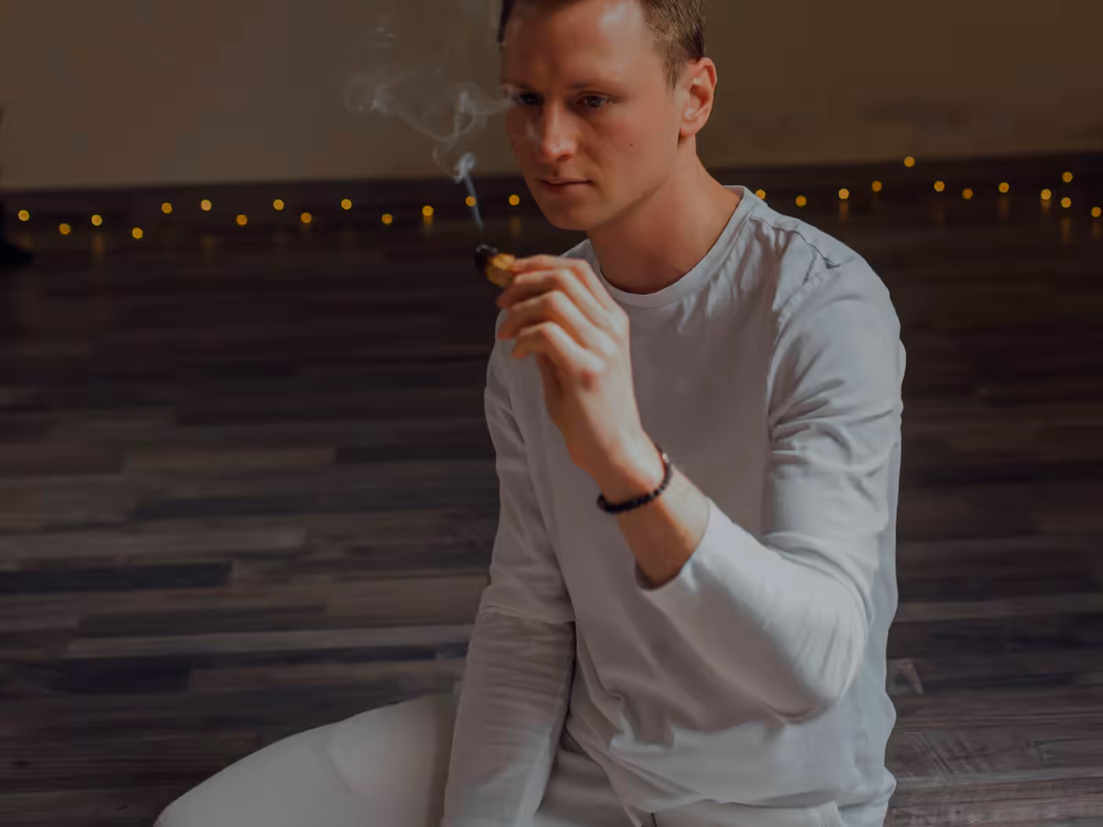 Méditation en tenue blanche ample, en lumière tamisée
